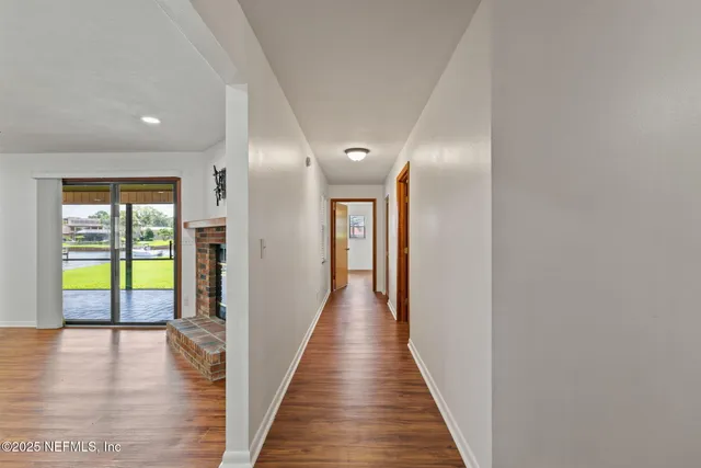a view of a hallway with wooden floor and windows