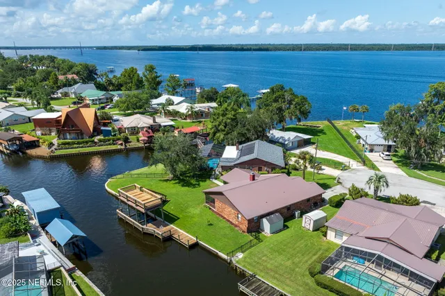 an aerial view of a house with a garden and lake view