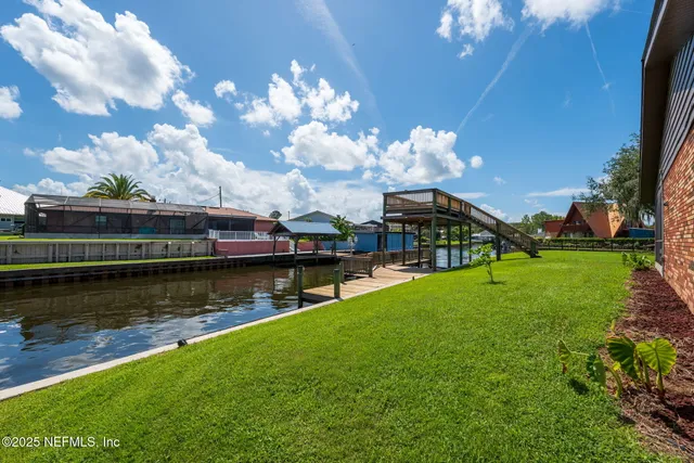 a view of a house with wooden deck and a big yard