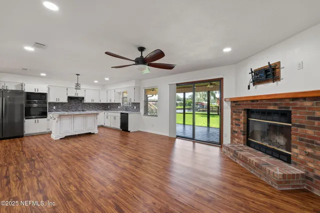 a view of kitchen with a refrigerator and a fireplace