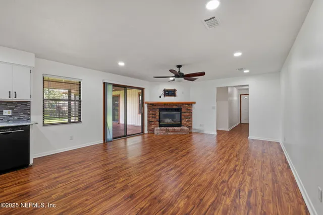a view of empty room with wooden floor and fireplace