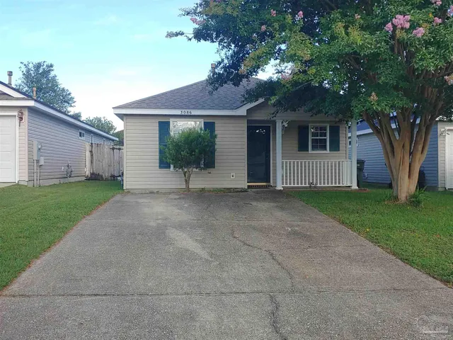 a view of a house with a tree and garden