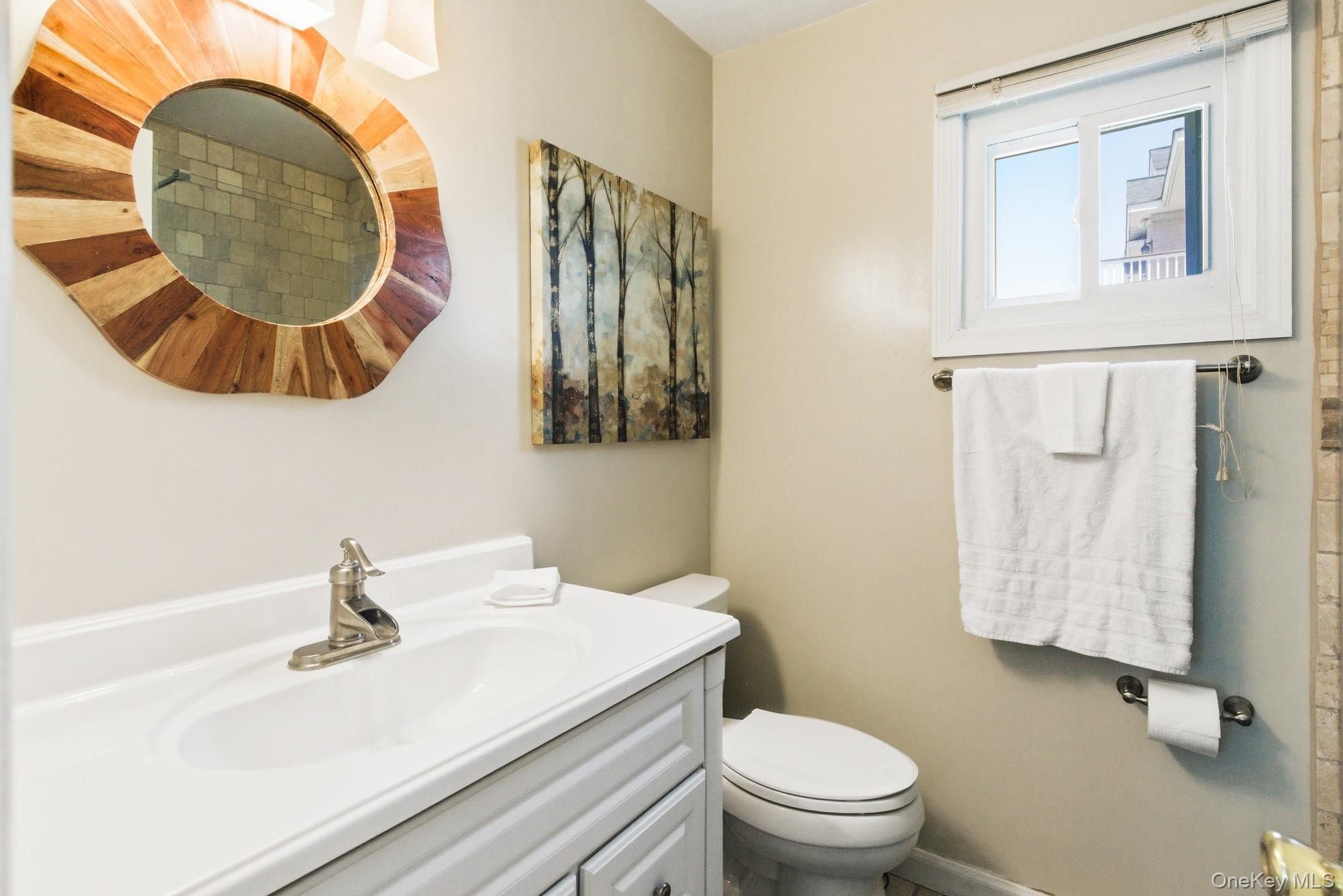 818 Dune Road Westhampton Beach, NY 11978 - Photo 11 of 30 a bathroom with a sink a mirror and toilet