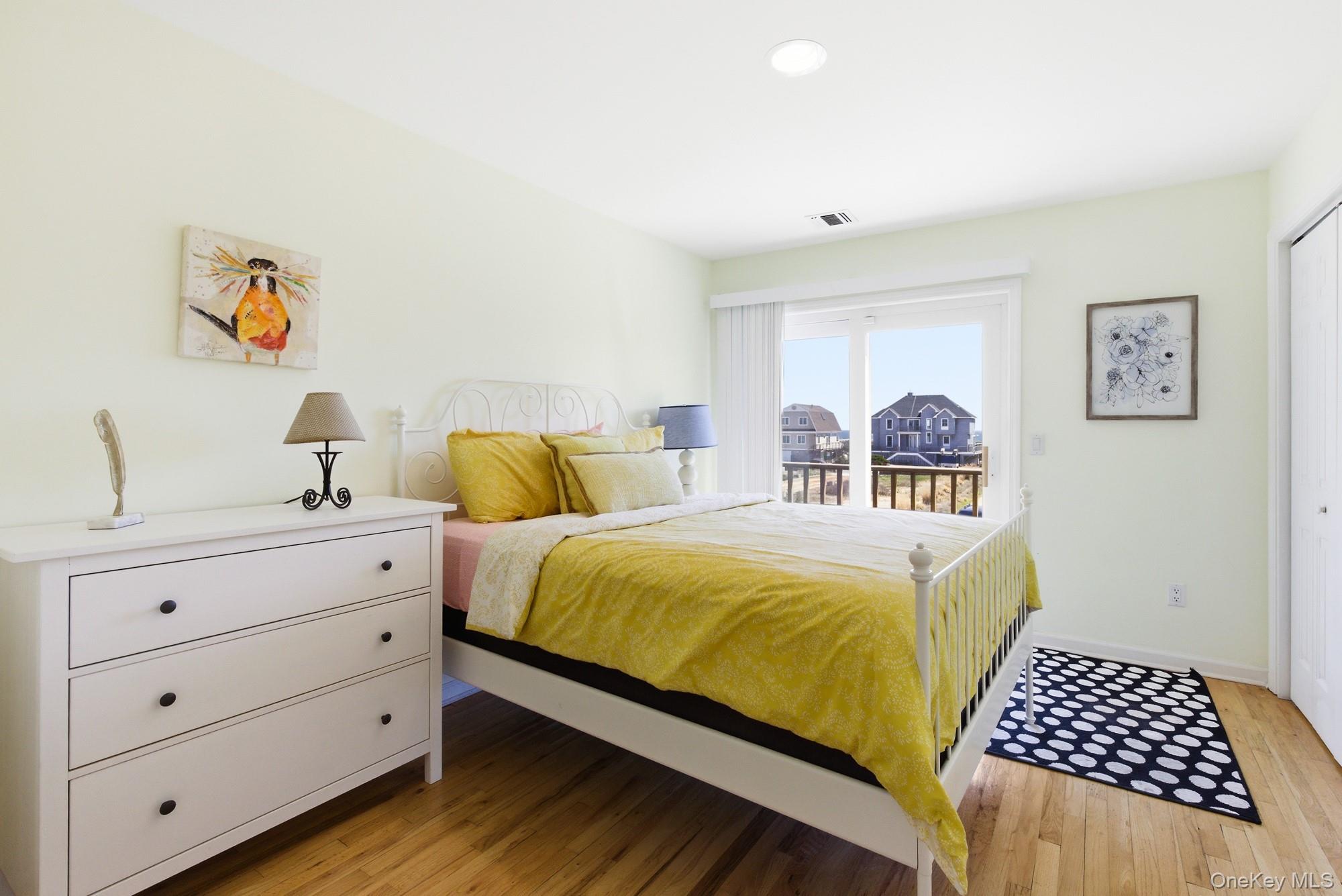 818 Dune Road Westhampton Beach, NY 11978 - Photo 14 of 30 a bedroom with a bed and wooden floor