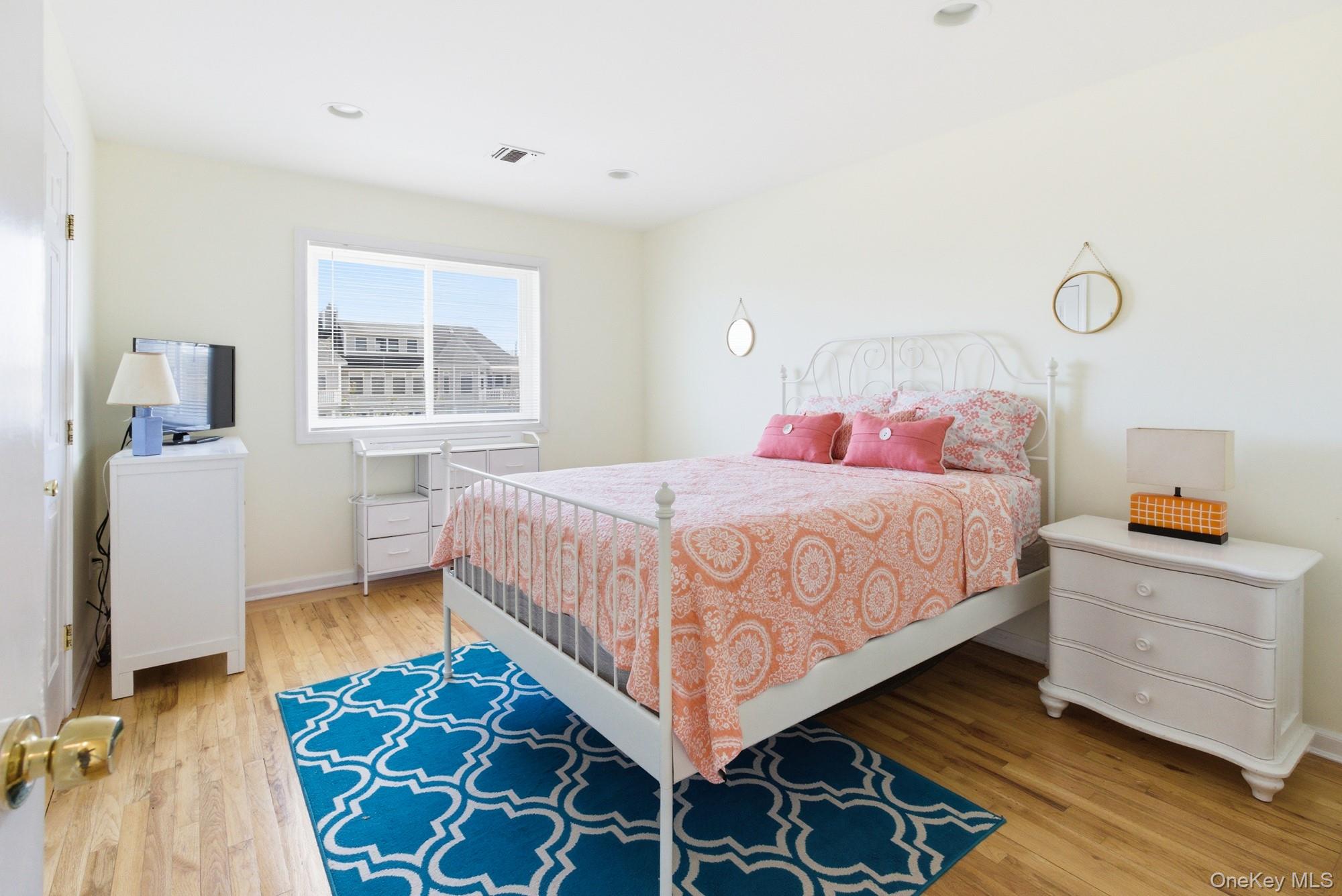 818 Dune Road Westhampton Beach, NY 11978 - Photo 16 of 30 a bedroom with a bed and wooden floor