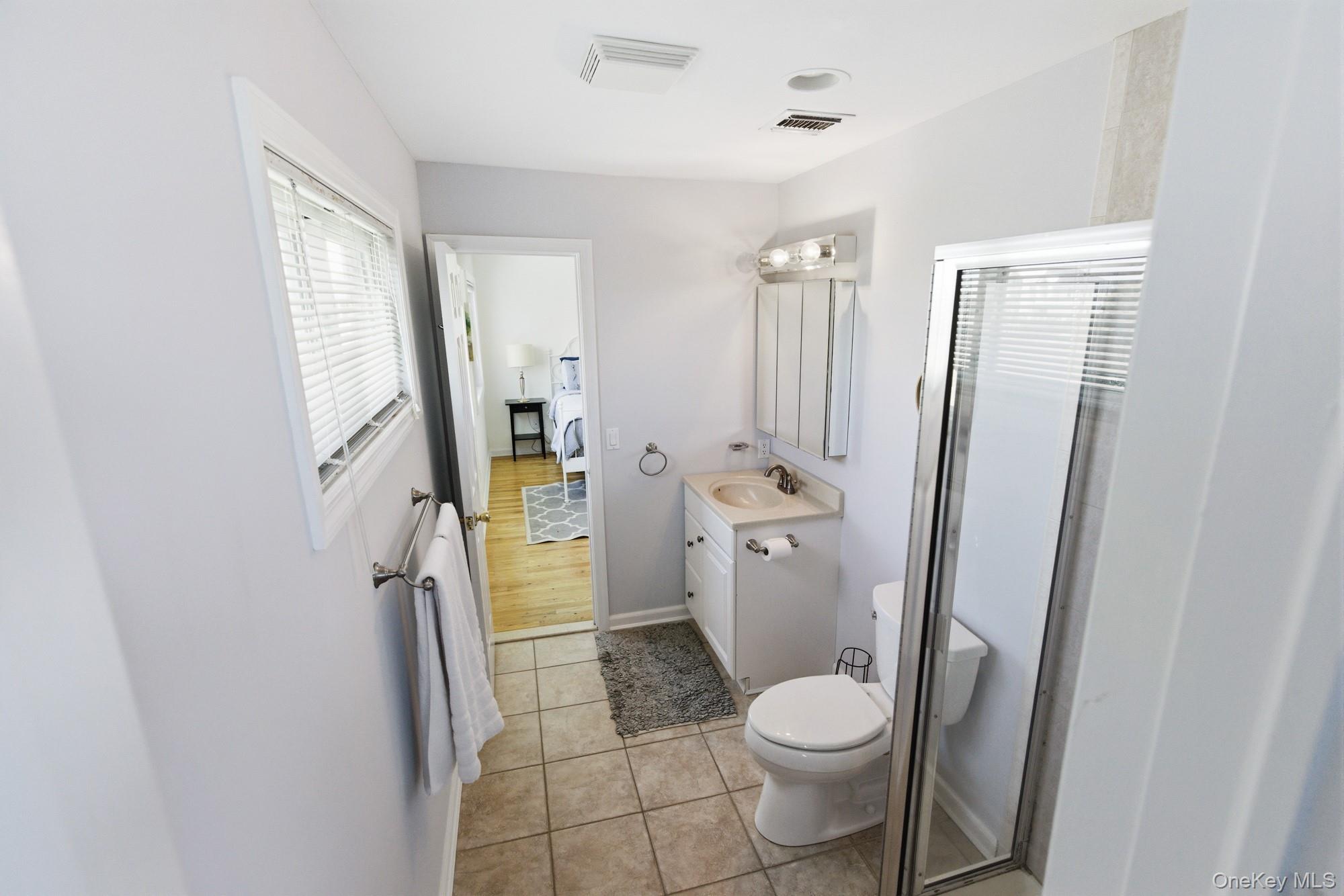 818 Dune Road Westhampton Beach, NY 11978 - Photo 20 of 30 a white toilet sitting next to a bathroom sink and a shower