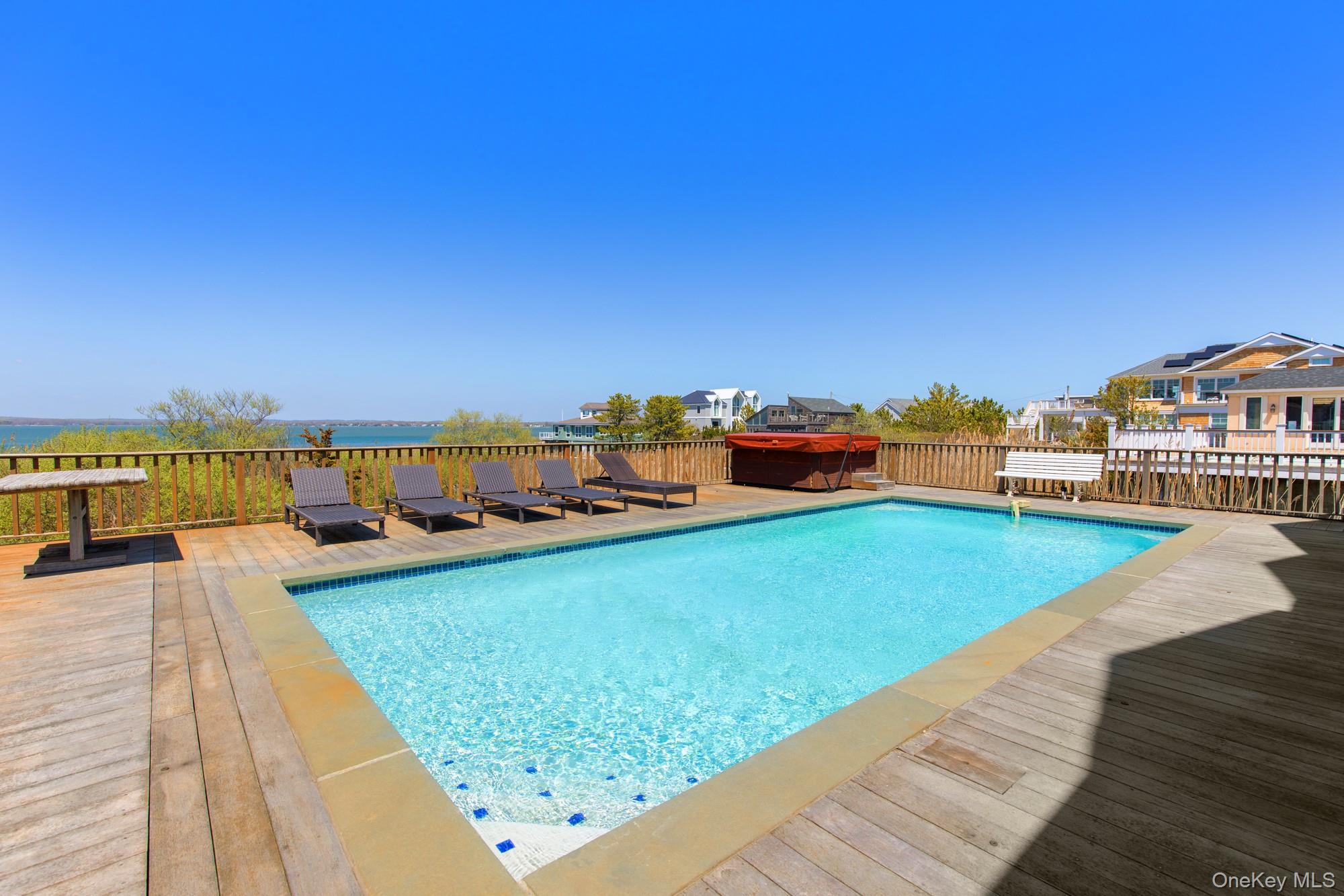 818 Dune Road Westhampton Beach, NY 11978 - Photo 3 of 30 a view of a swimming pool and an ocean from a seating space