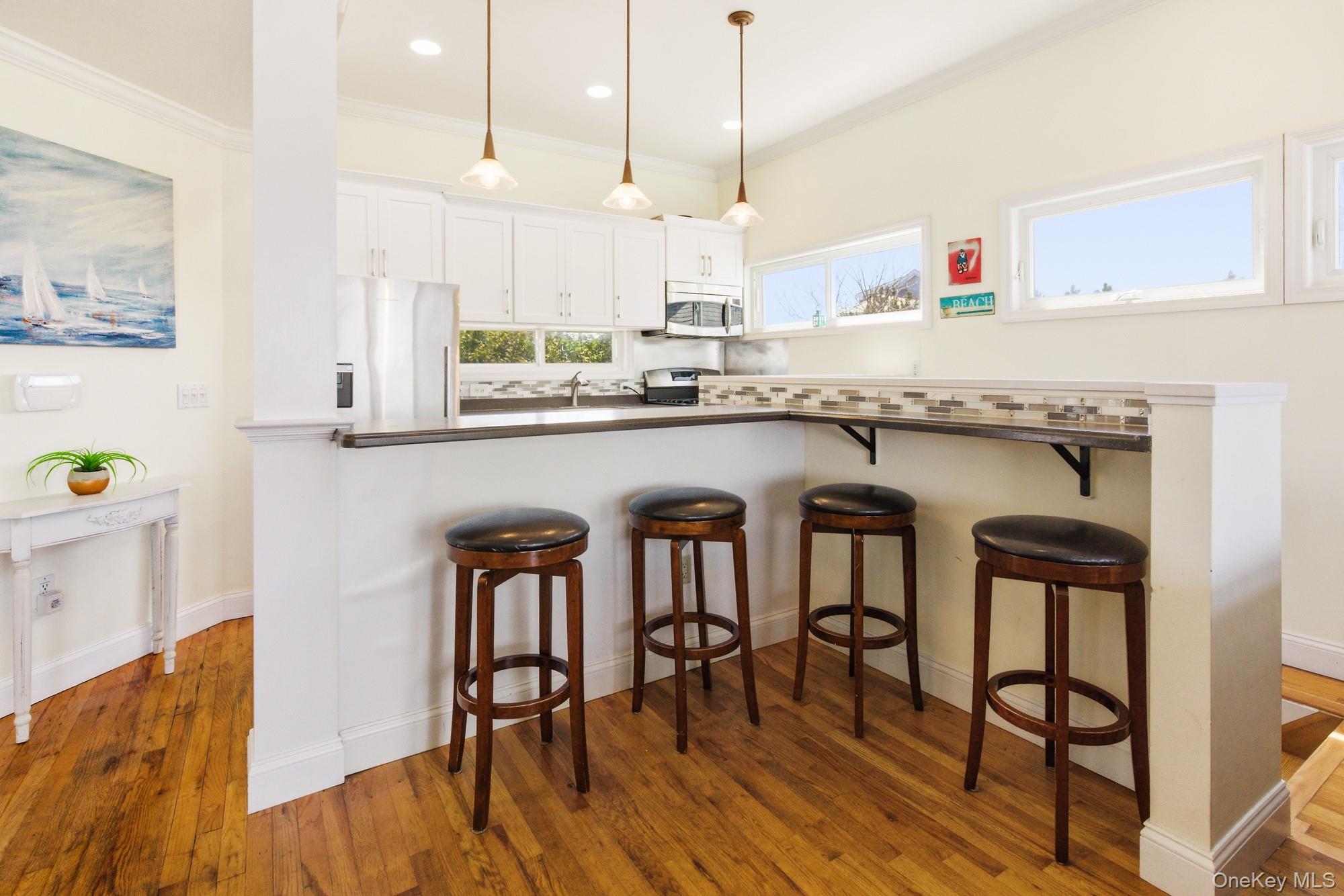 818 Dune Road Westhampton Beach, NY 11978 - Photo 7 of 30 a kitchen with stainless steel appliances granite countertop a table chairs stove refrigerator and cabinets