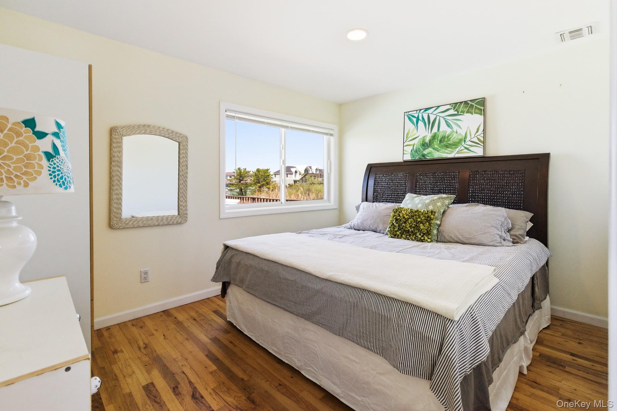 818 Dune Road Westhampton Beach, NY 11978 - Photo 10 of 30 a bedroom with a bed and a painting on the wall