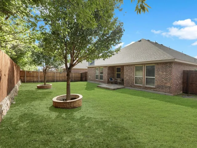 a backyard of a house with table and chairs