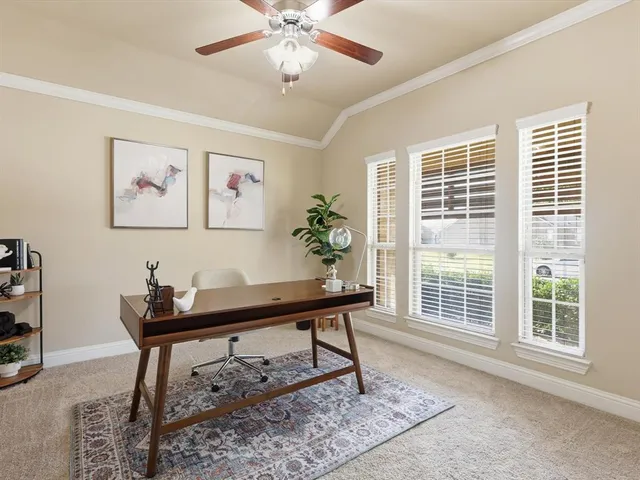 a view of a workspace with furniture and a window