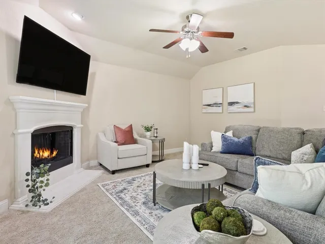 a living room with furniture a fireplace and a flat screen tv