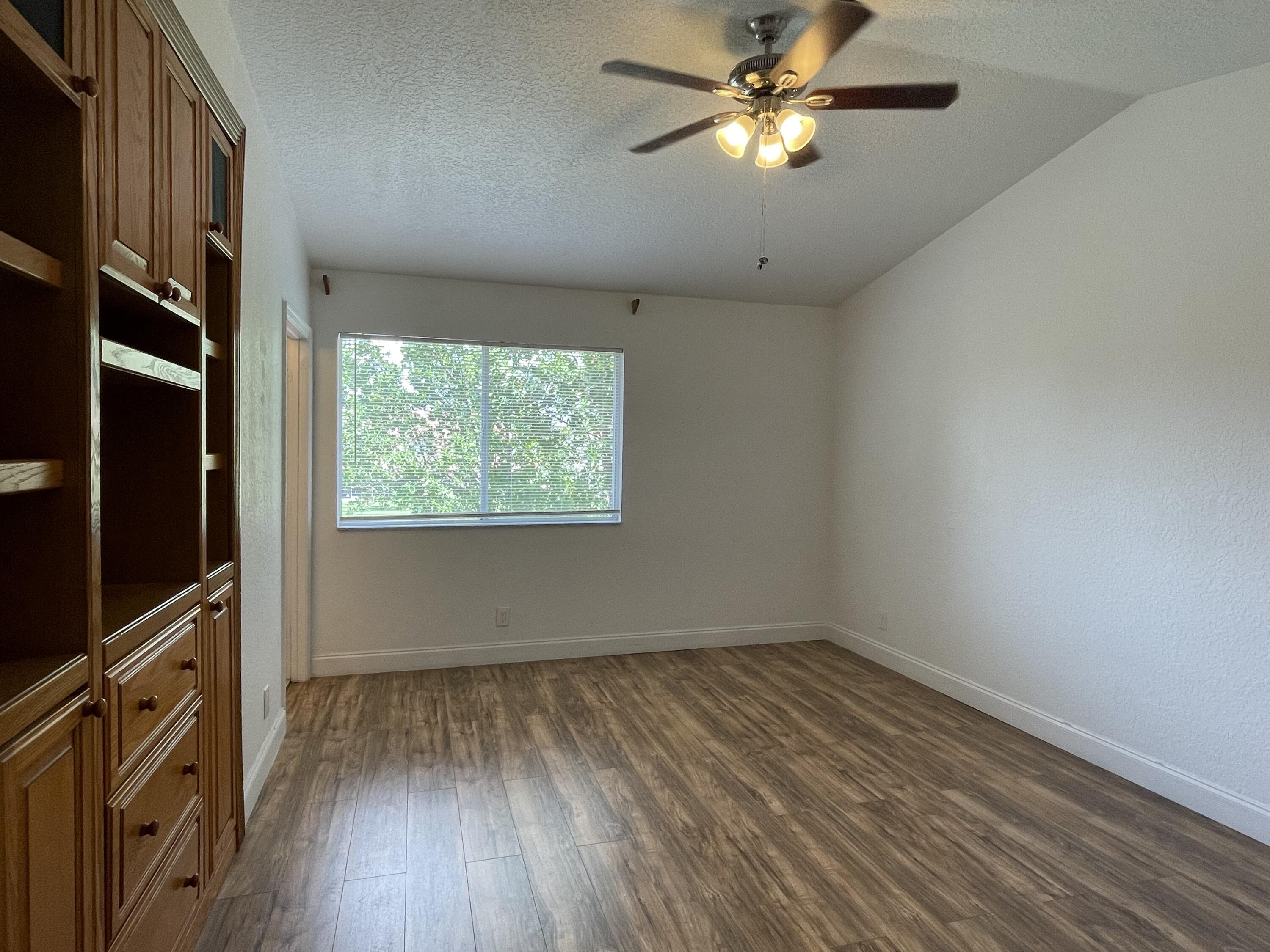 6204 Sandy Bank Terrace West Palm Beach, FL 33407 - Photo 16 of 37 wooden floor in an empty room with a window