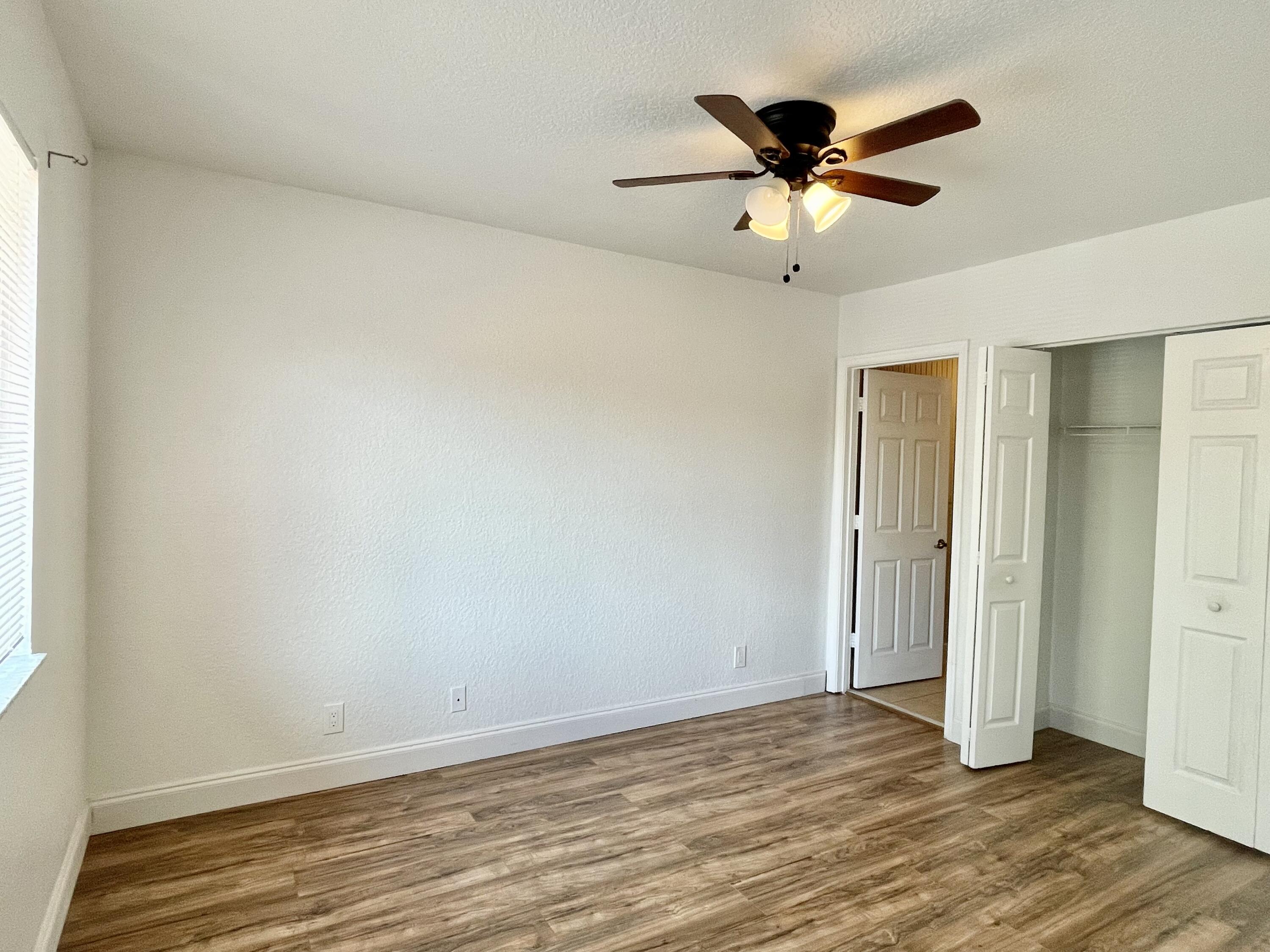 6204 Sandy Bank Terrace West Palm Beach, FL 33407 - Photo 20 of 37 an empty room with wooden floor and ceiling fan