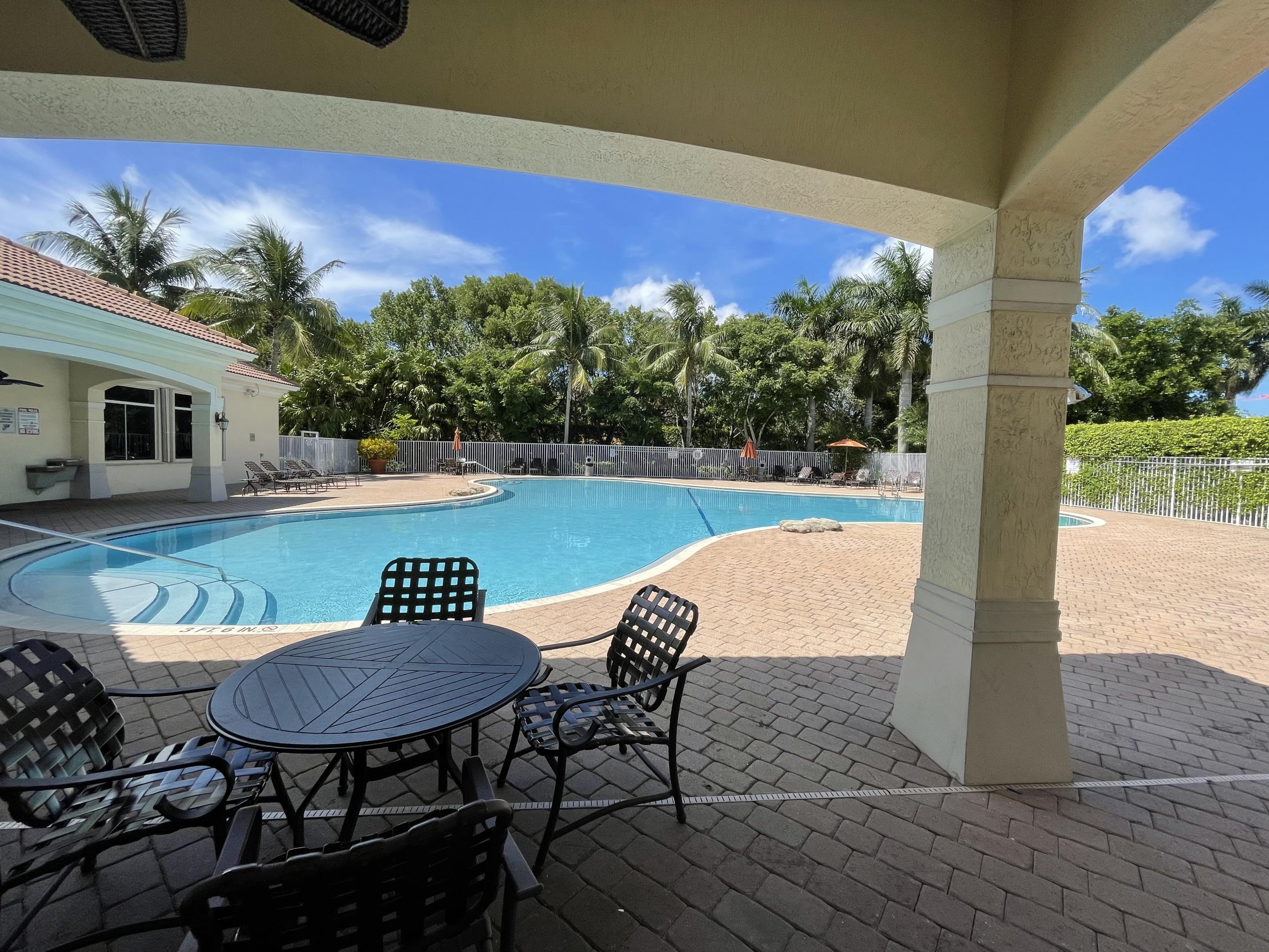 6204 Sandy Bank Terrace West Palm Beach, FL 33407 - Photo 27 of 37 a view of a chairs and table in patio with a yard