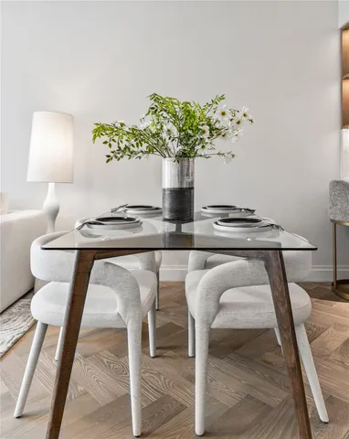a table with a vase and flowers on it with wooden floor