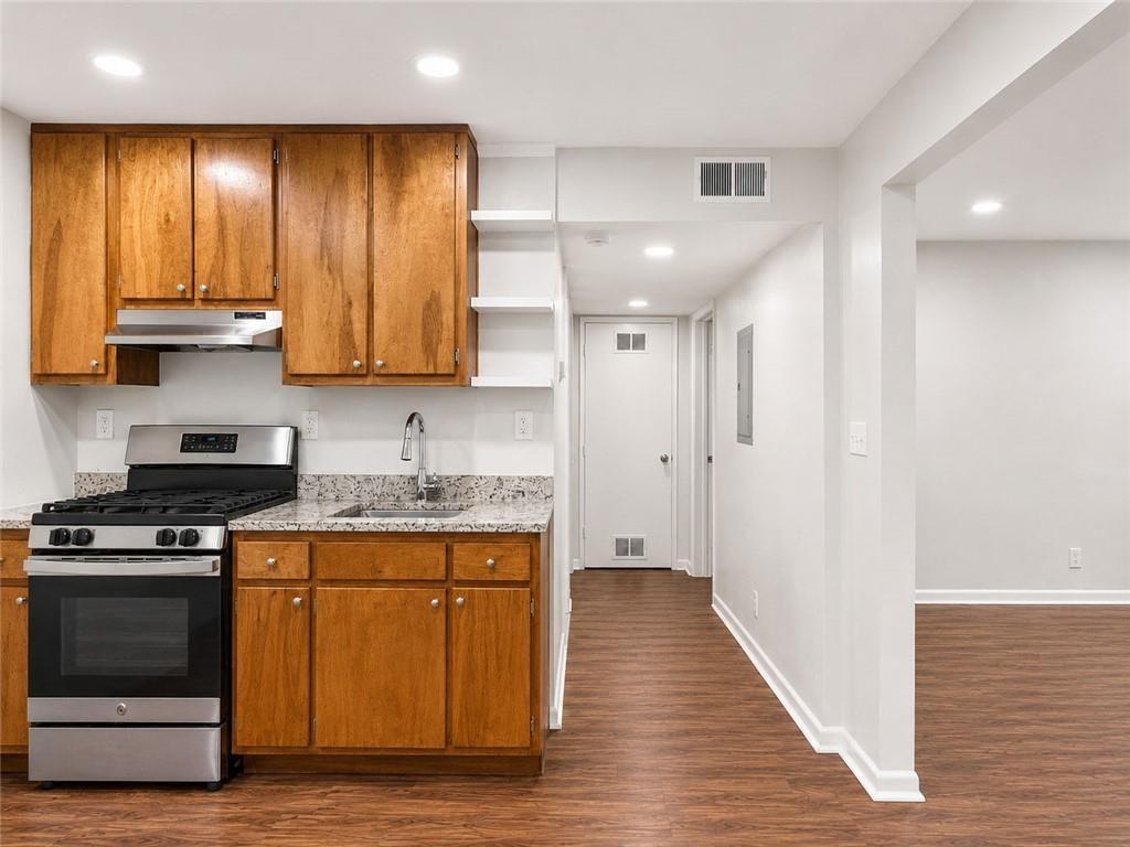 3203 East Point Street, Unit 4 Atlanta, GA 30344 - Photo 7 of 18 a kitchen with granite countertop wooden floors and stainless steel appliances