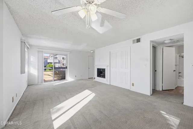 a view of a livingroom with an empty space and a ceiling fan