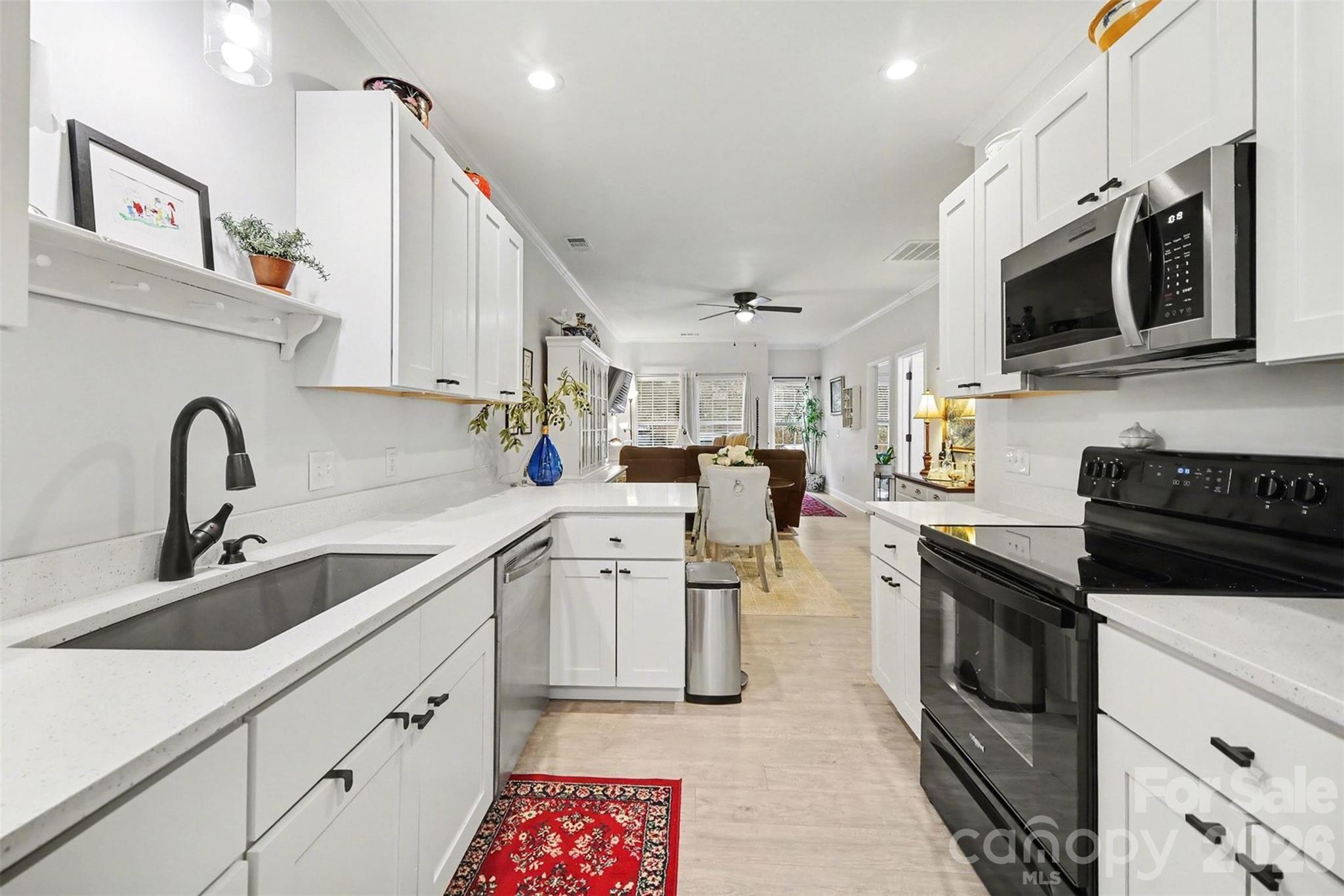 3236 Cottage Rose Lane Rock Hill, SC 29732 - Photo 3 of 27 a kitchen with stainless steel appliances a sink a stove top oven a chimney cabinets and a counter top space