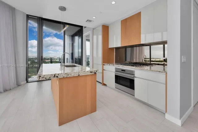 a large kitchen with kitchen island granite countertop a large window