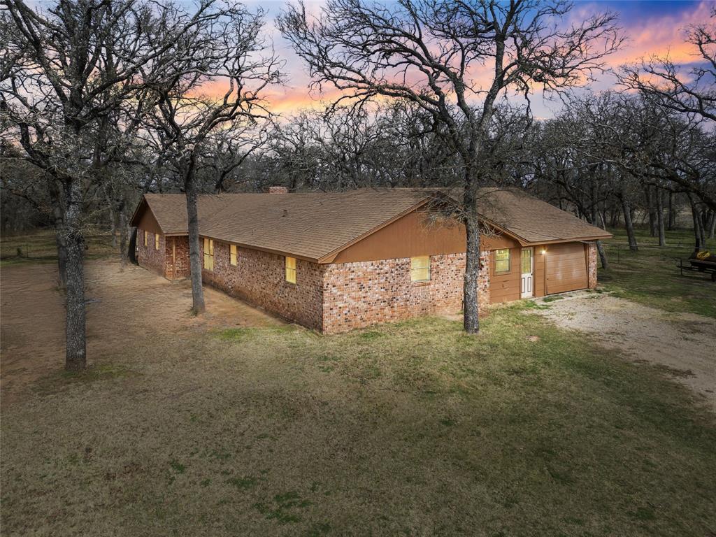 a view of a house with a yard and tree s