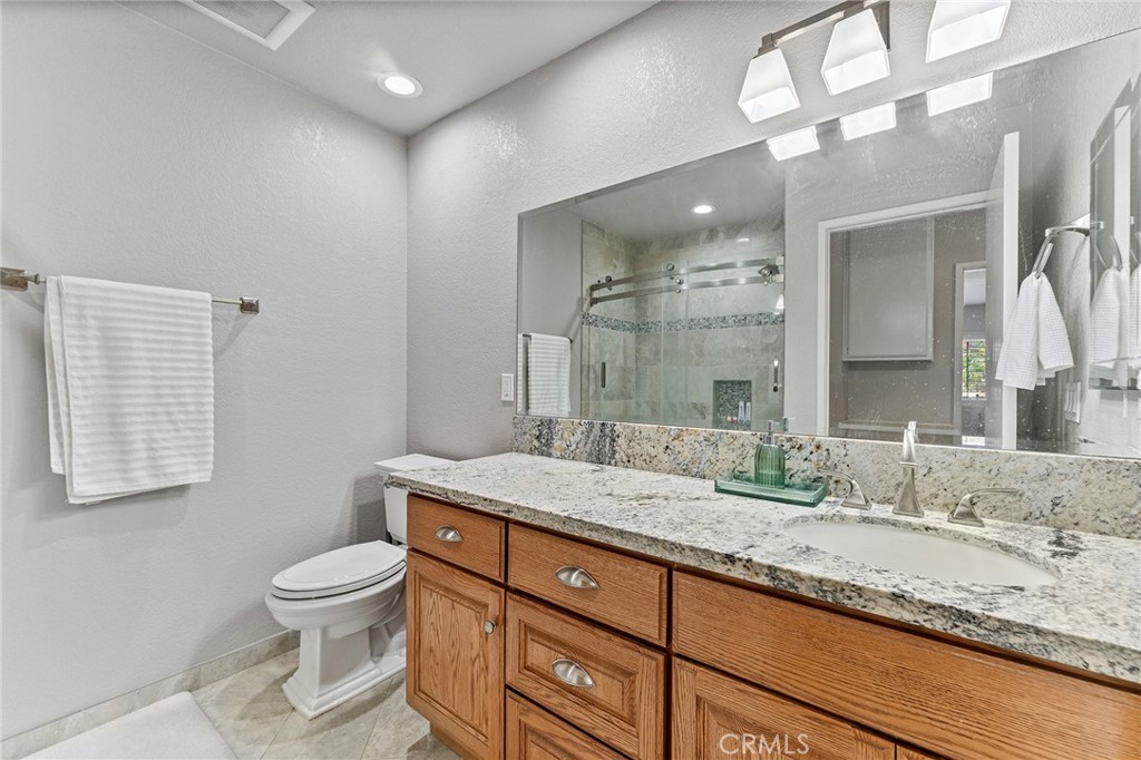 15 Ravencrest Circle Phillips Ranch, CA 91766 - Photo 17 of 22 a bathroom with a granite countertop sink a toilet and mirror