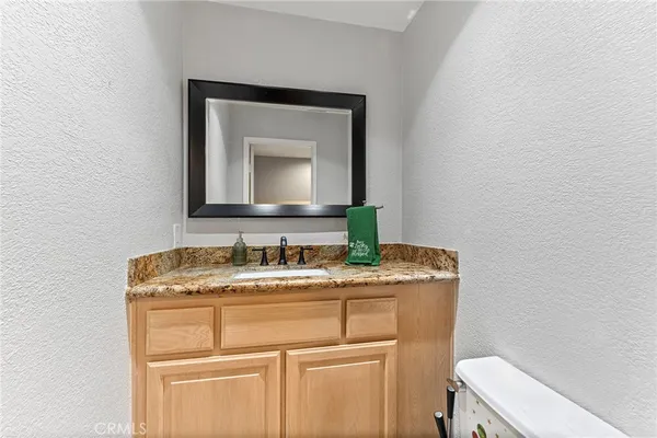 a bathroom with a granite countertop sink vanity and mirror