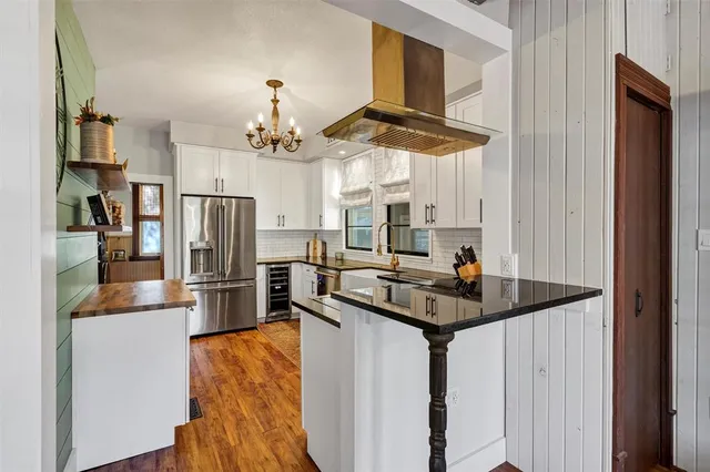 a kitchen with stainless steel appliances granite countertop a sink a refrigerator and a granite counter tops