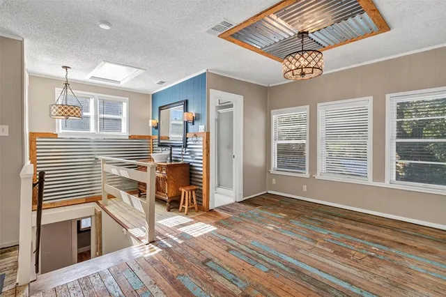 a view of a livingroom with wooden floor and furniture