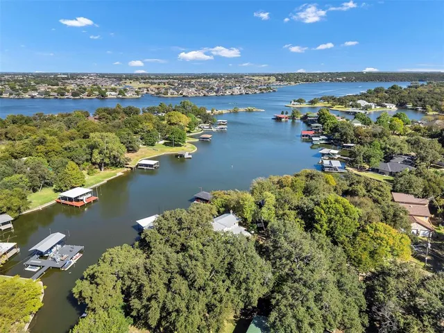 an aerial view of residential houses with outdoor space and lake view