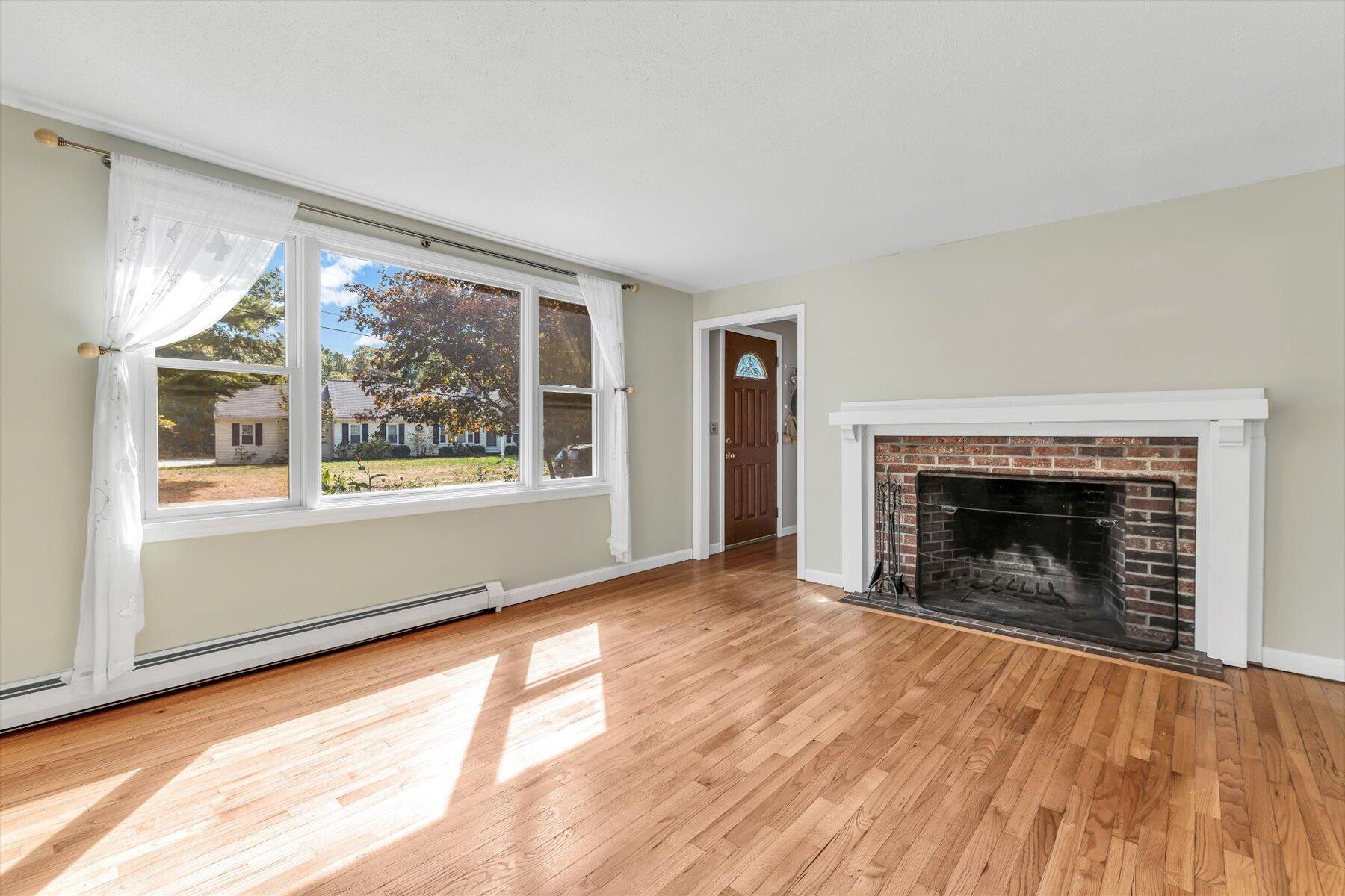 80 Curlew Way Cotuit, MA 02635 - Photo 13 of 37 wooden floor fireplace and windows in an empty room
