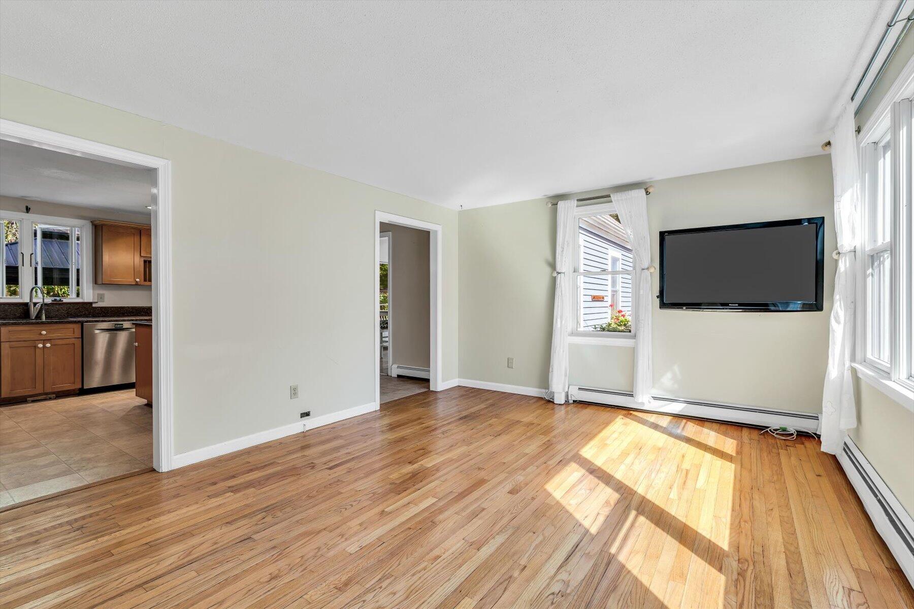 80 Curlew Way Cotuit, MA 02635 - Photo 14 of 37 a view of empty room with wooden floor and flat screen tv