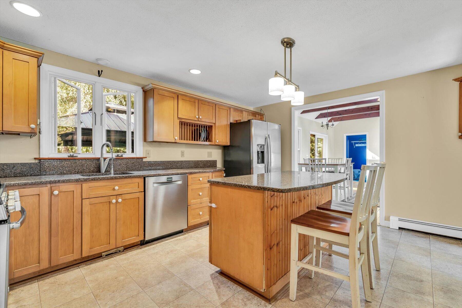 80 Curlew Way Cotuit, MA 02635 - Photo 8 of 37 a kitchen with stainless steel appliances granite countertop wooden cabinets a dining table and chairs