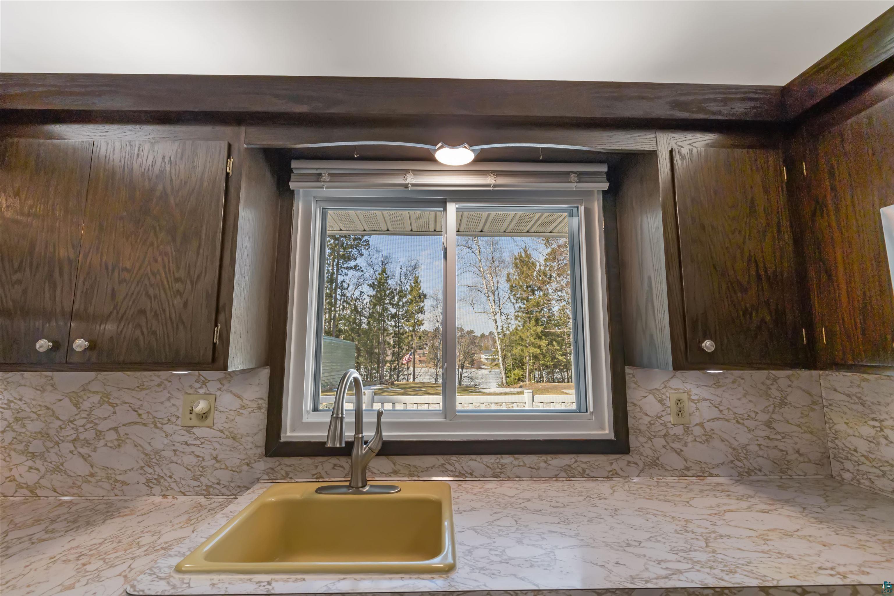 3975 Long Lake Shores Road Eveleth, MN 55734 - Photo 21 of 84 Kitchen featuring dark wood finish cabinets, light countertops, and tasteful backsplash