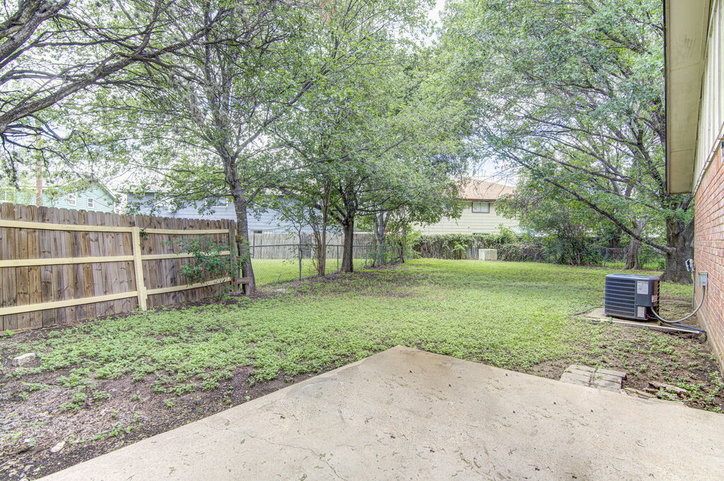 5301 Indio Circle, Unit A Austin, TX 78745 - Photo 18 of 25 Secure backyard offers ample space for recreation and relaxation, framed by mature trees.