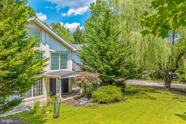 a backyard of a house with table and chairs under an umbrella