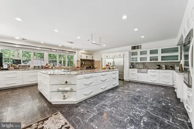 a kitchen with stainless steel appliances a lot of white cabinets