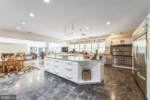 a kitchen with stainless steel appliances granite countertop a sink and a refrigerator