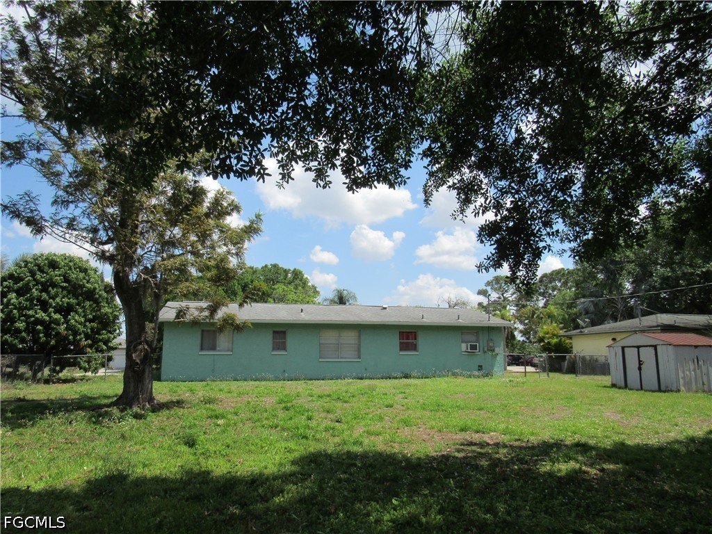 2976 Ribbon Court Fort Myers, FL 33905 - Photo 3 of 16 a backyard of a house with plants and a large tree