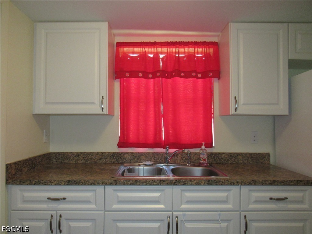 2976 Ribbon Court Fort Myers, FL 33905 - Photo 5 of 16 a kitchen with red cabinets and granite counter tops
