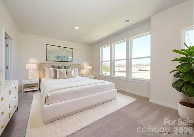 a bedroom with a large bed and a potted plant