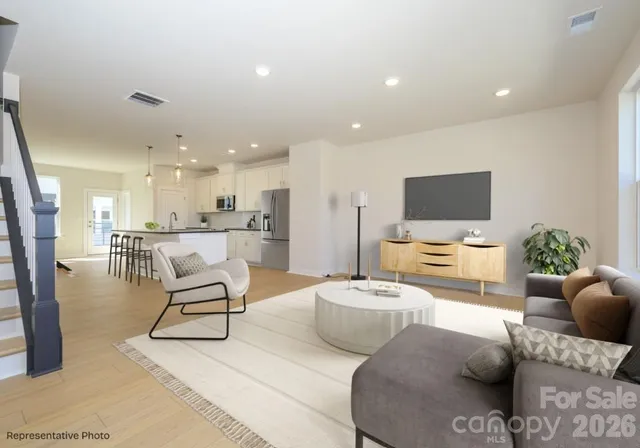 a living room with furniture and a view of kitchen
