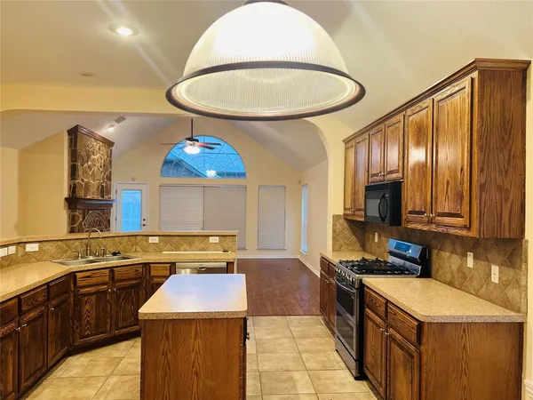 a kitchen with stainless steel appliances a stove a sink and a microwave
