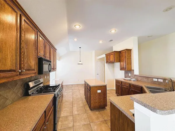a kitchen with stainless steel appliances granite countertop a sink a stove and a refrigerator