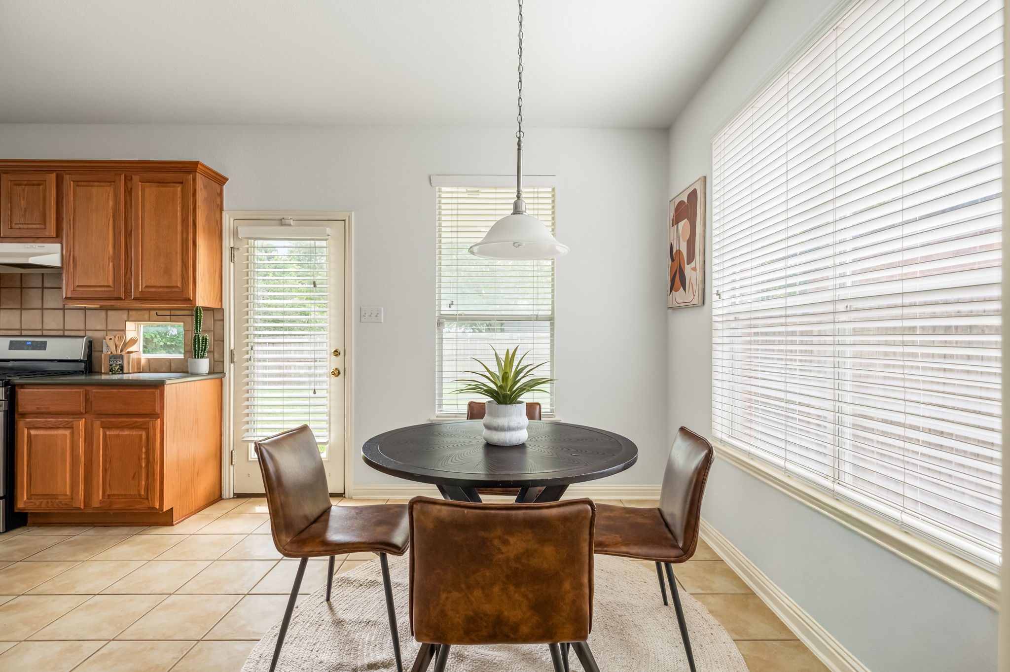10004 Isle Royale Way Austin, TX 78747 - Photo 13 of 31 A well-lit kitchen dining area features warm cabinetry and direct outdoor access.