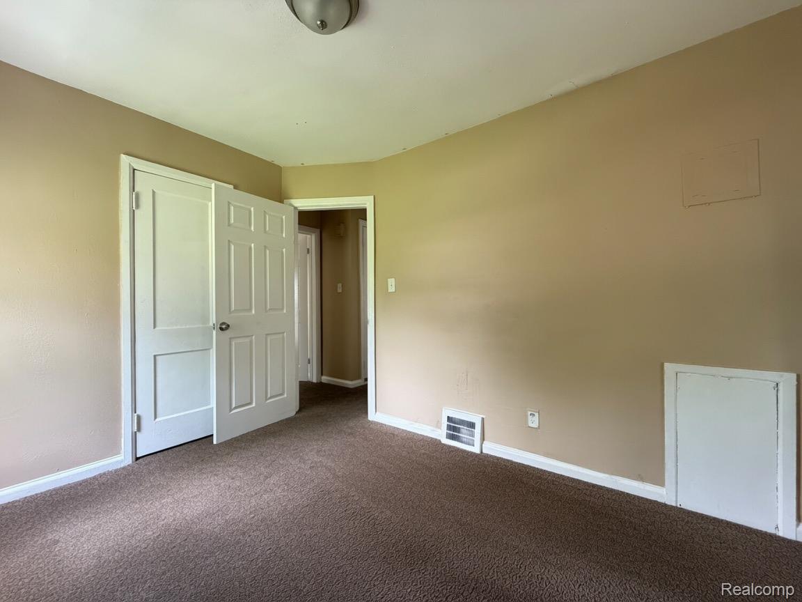 7286 Faust Avenue Detroit, MI 48228 - Photo 12 of 19 Neutral-toned walls complement a brown carpeted floor
