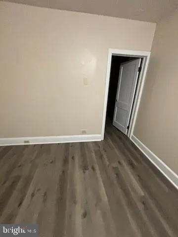an empty room with wooden floor and closet