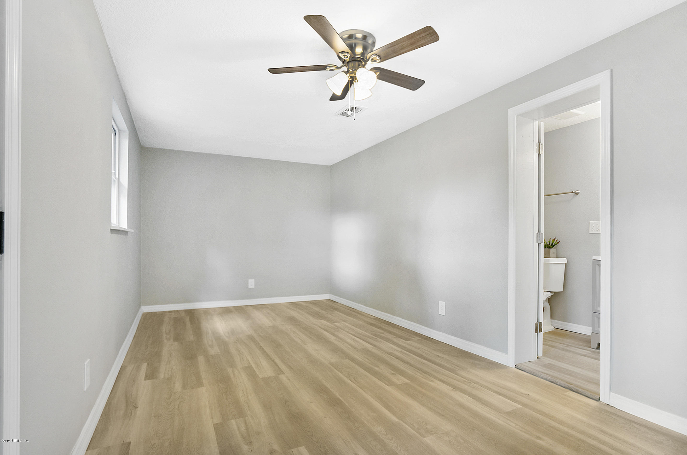 10483 Tulsa Road Jacksonville, FL 32218 - Photo 12 of 30 an empty room with a ceiling fan and wooden floor