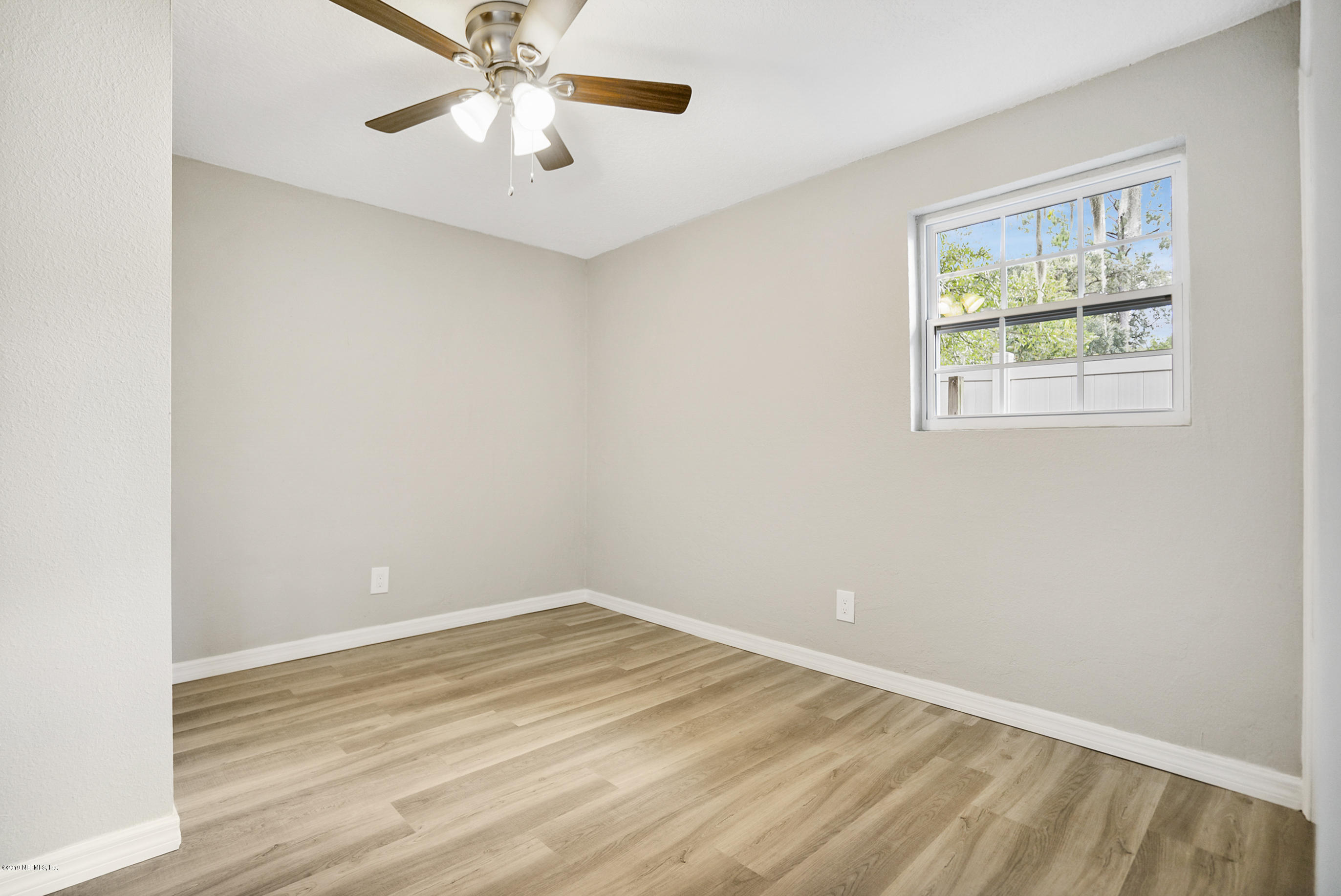 10483 Tulsa Road Jacksonville, FL 32218 - Photo 8 of 30 an empty room with a window and a fan