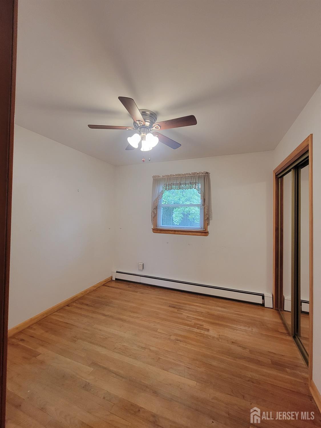 937 North Concourse Keyport, NJ 07735 - Photo 18 of 27 an empty room with wooden floor fan and windows